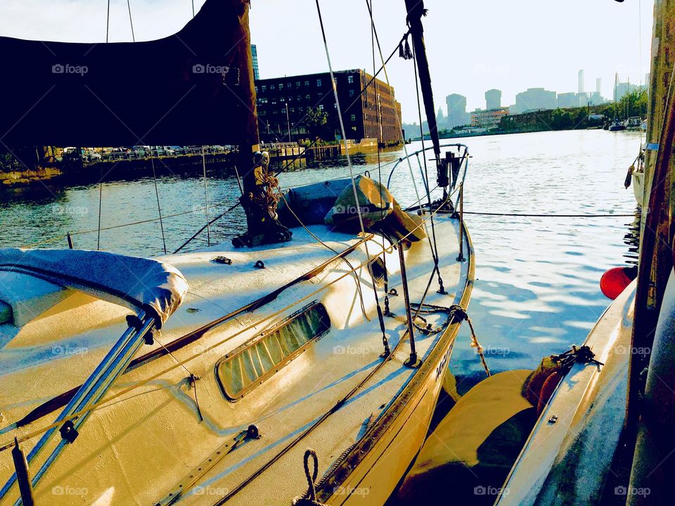 View of another sailboat from ours in the waters of the East River at Newtown Creek in Queens, NY in the late afternoon to early evening just as the sun is beginning to set. This photo was taken in the Spring of 2018. Hypnotic Productions