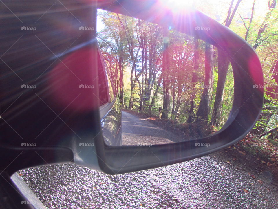 reflected in the rearview mirror, the road behind