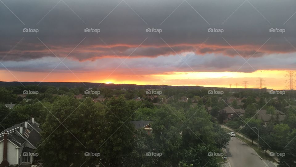 Sunset Over the escarpment through my apartment window in Ontario, oranges and pinks mixing with the Grey clouds overhead 
