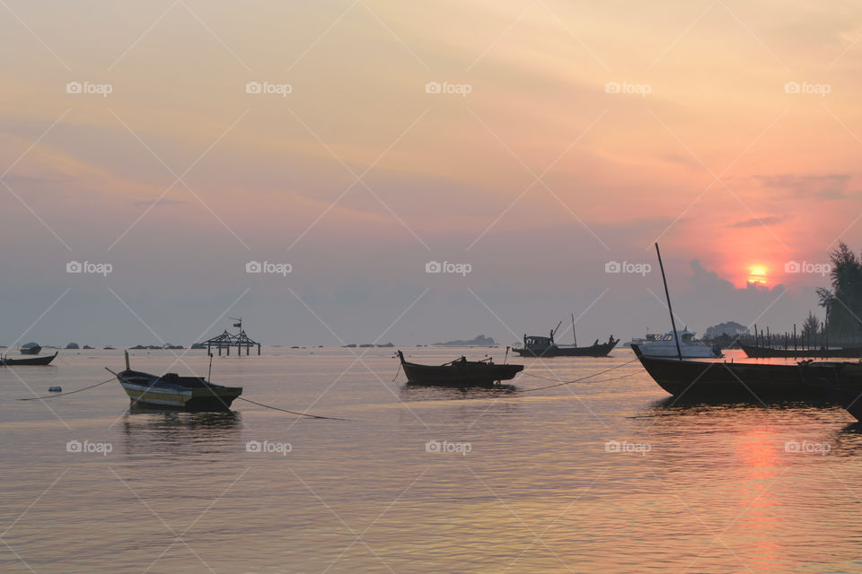 traditional fishing boat against sunrise