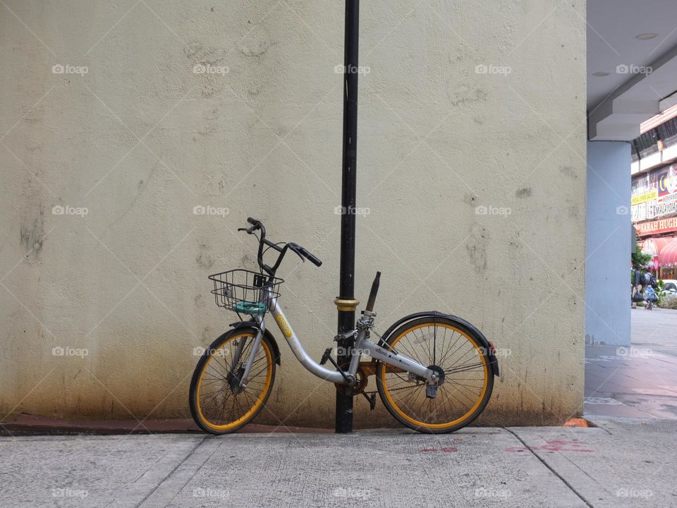 Vandalised bicycle for hire chained to a lamp post with the saddle missing