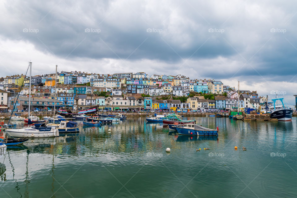 Small fishing port and colorful houses in town on a rocky cliff. Constant supply of fresh fish. Brixham.  Devon. UK.