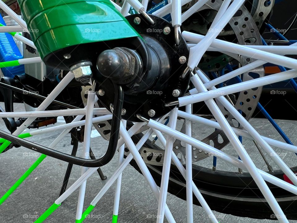 Macro photo of pristine white and green bicycle spokes. 