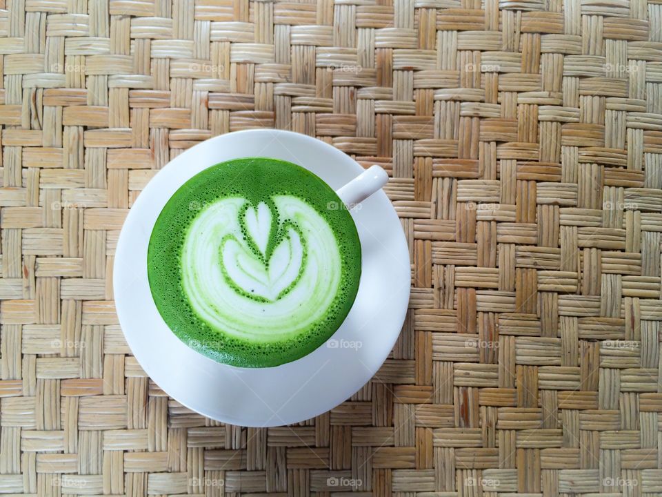 Top view of green coffee cup on wood background 