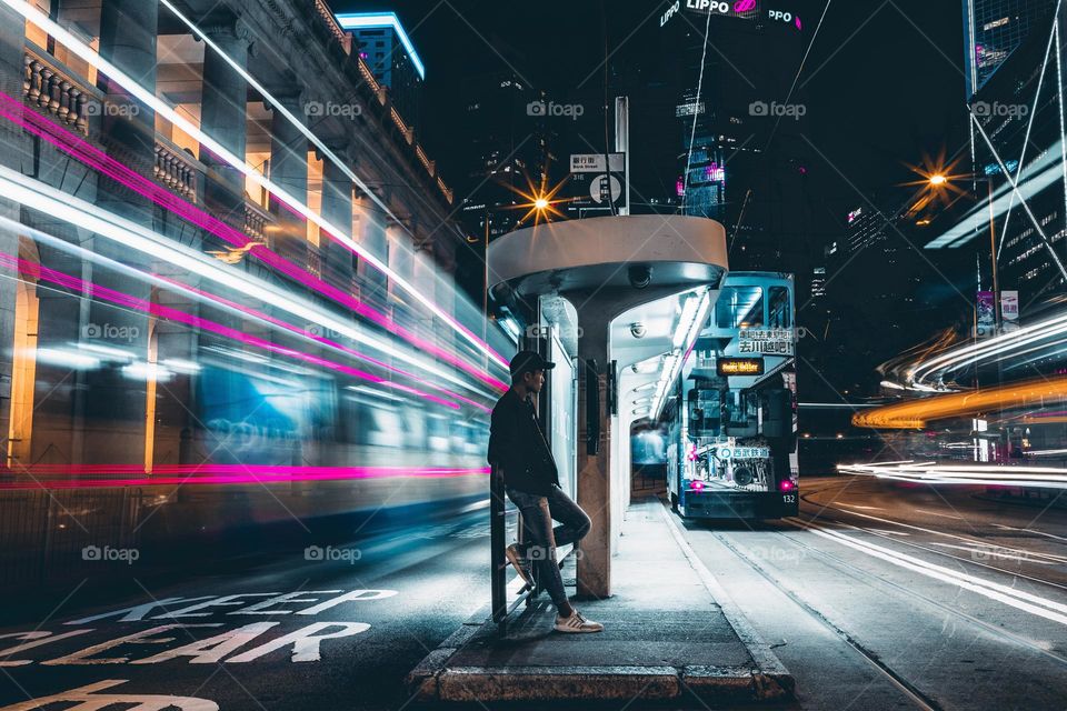 Portrait shot capturing the light trail of vehicles in Hong Kong at night
