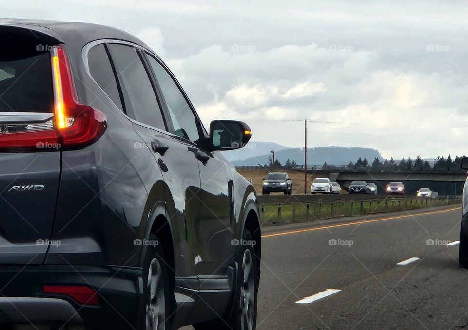 close up view of a black car passing by the camera in late afternoon Oregon commuter traffic