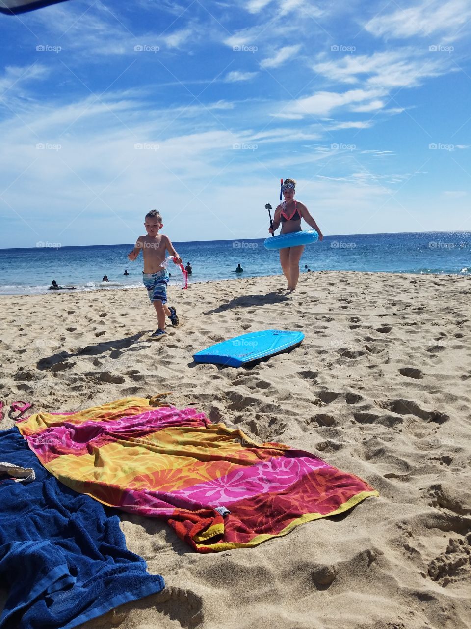 Boy and woman race up the beach after snorkeling