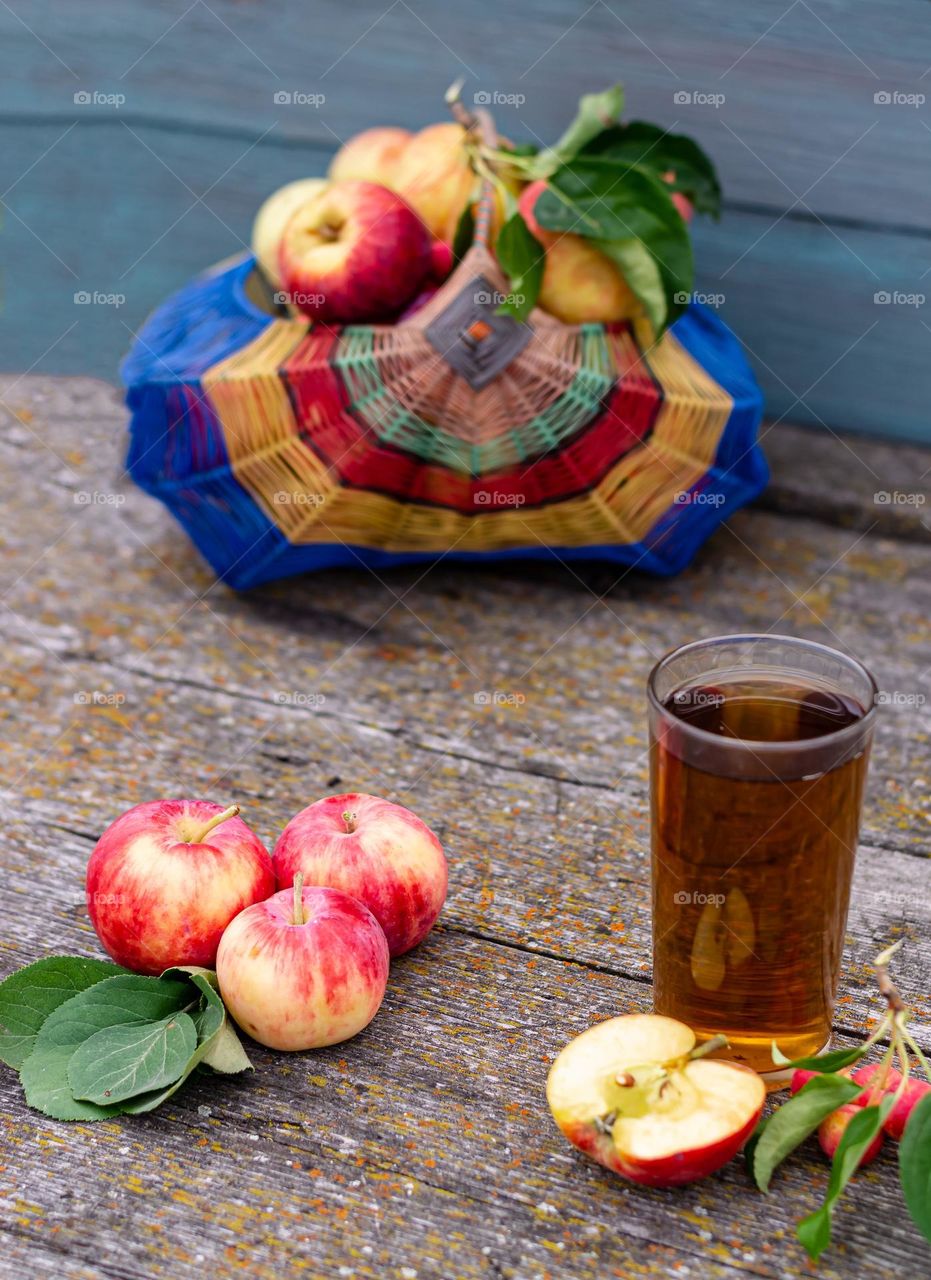 Food still life in a rustic style freshly squeezed apple juice in a glass and orchard apples on a wooden background