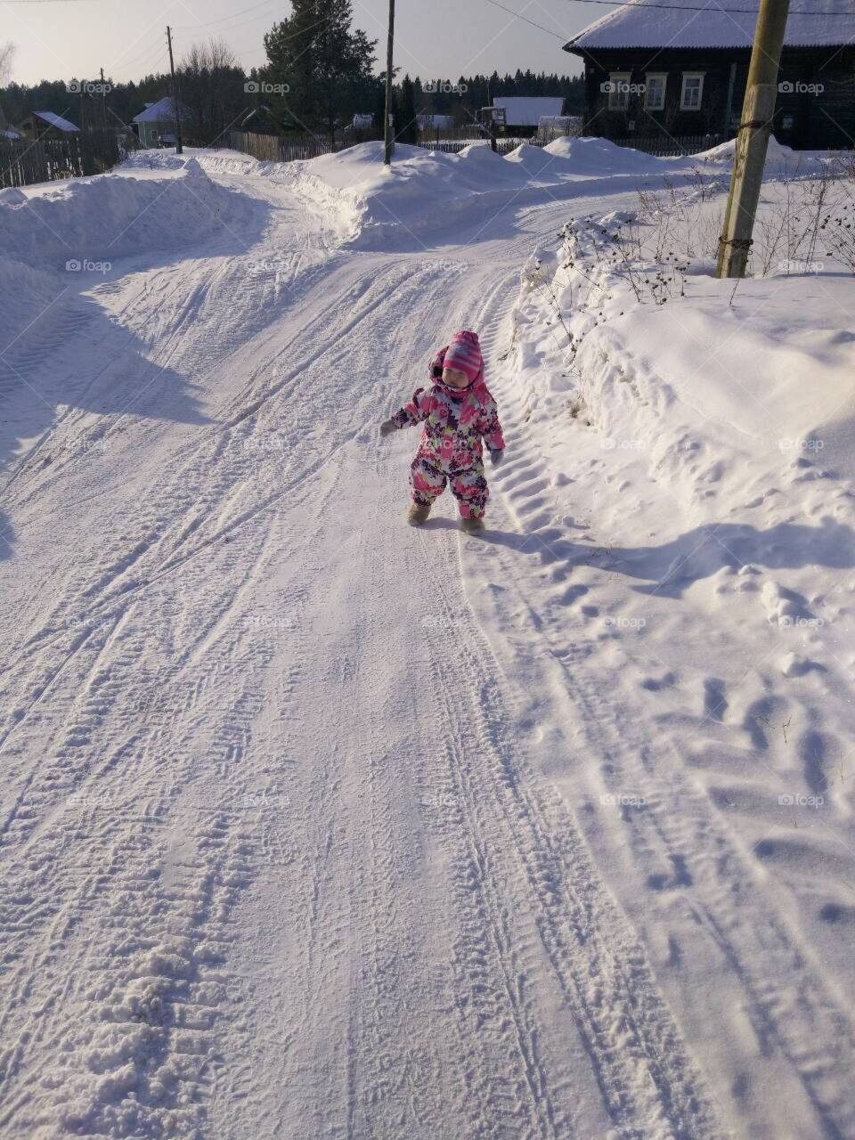 Ребёнок гуляет зимой с мамой 