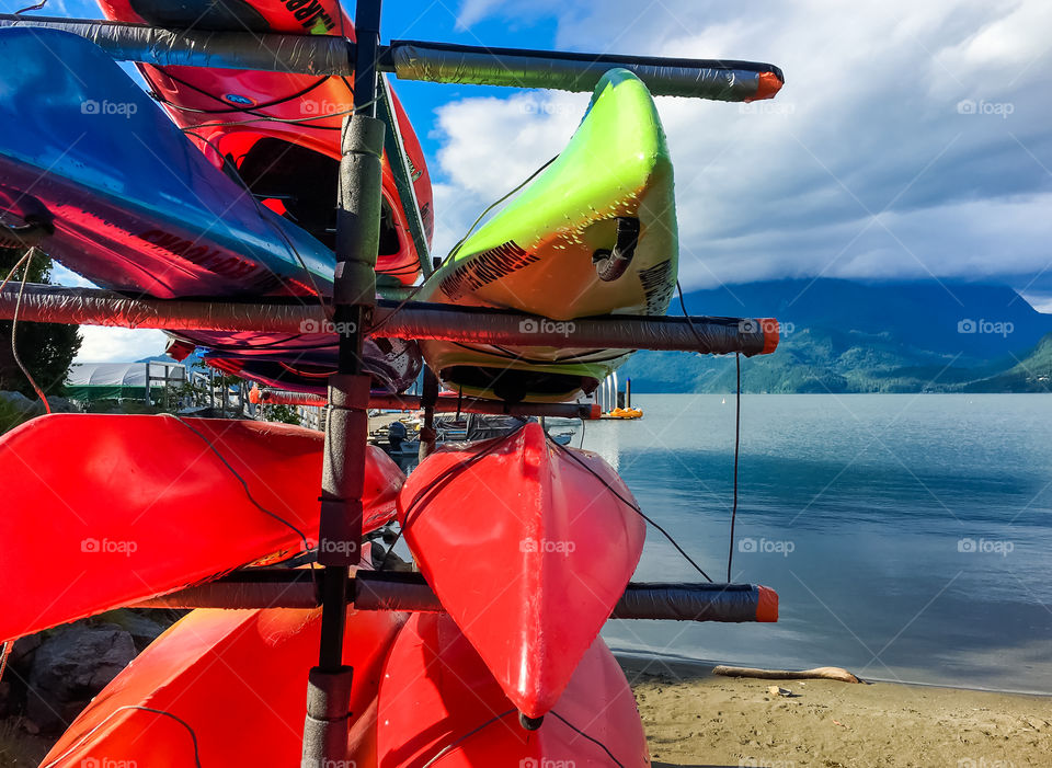Colourful kayaks in their cradles piled high at lake (Harrison shot springs Resort, British Columbia, Canada 