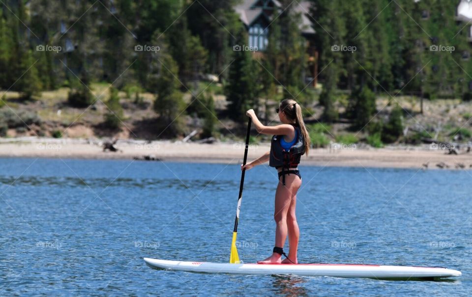 Young woman paddle-boarding in Dillon, CO 
