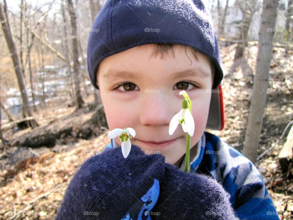 Boy holding first flowers blooming in Spring