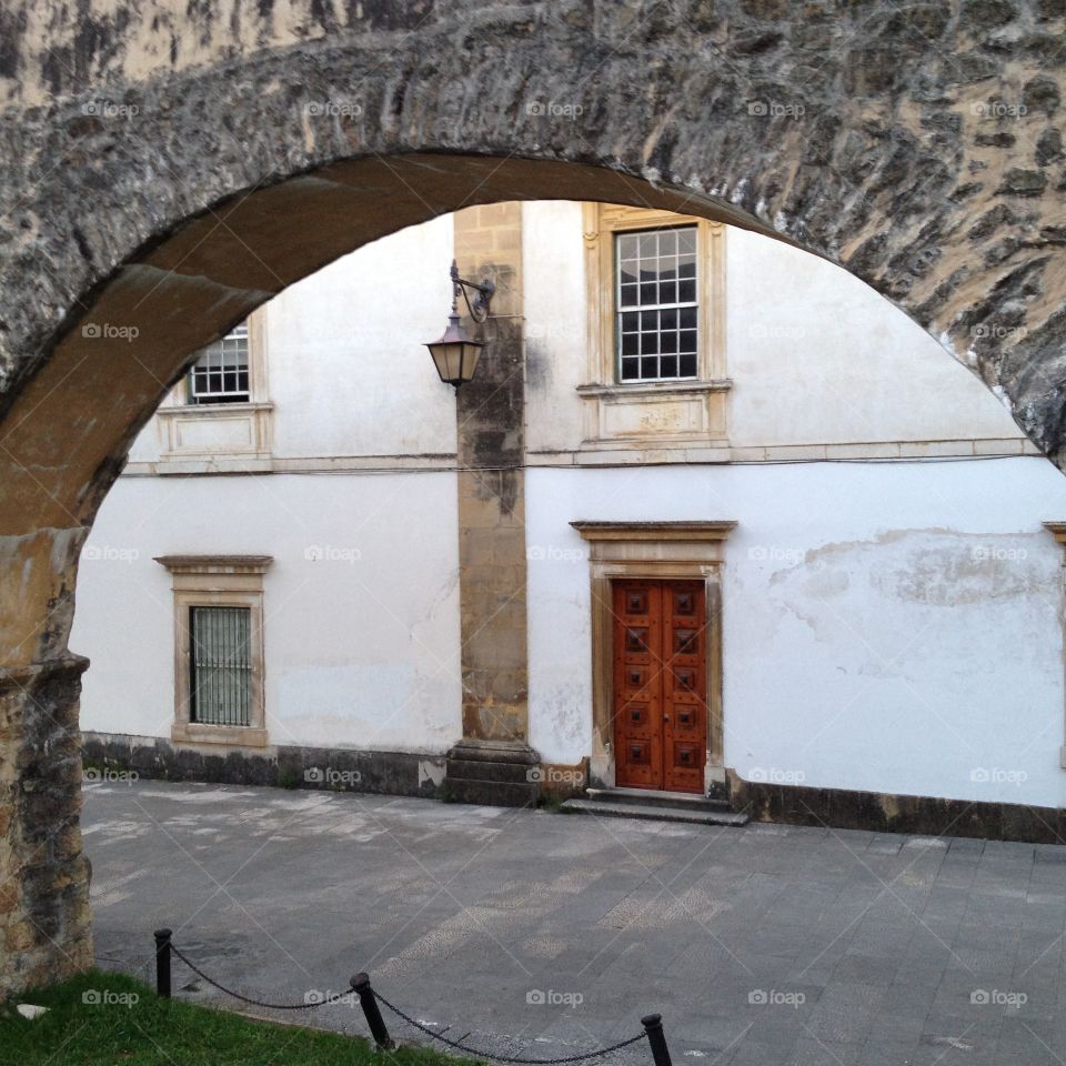 Old college with very old aqueduct arch