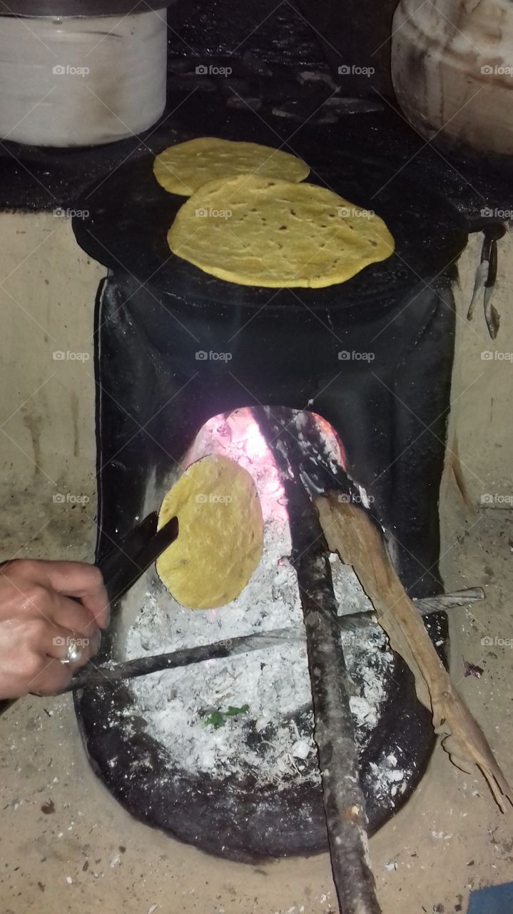 A person roasting roti
