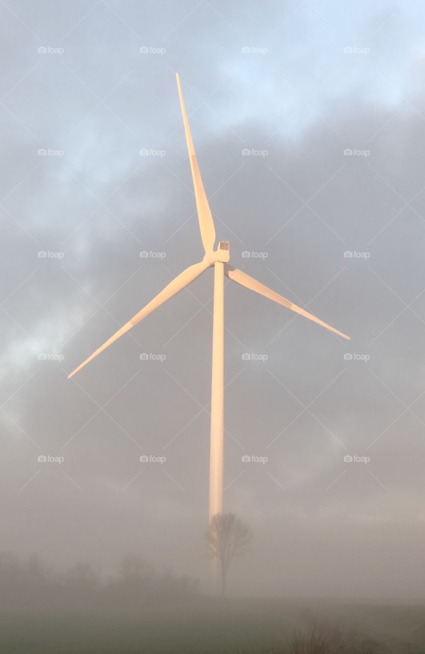 Wind turbine rising out of the mist