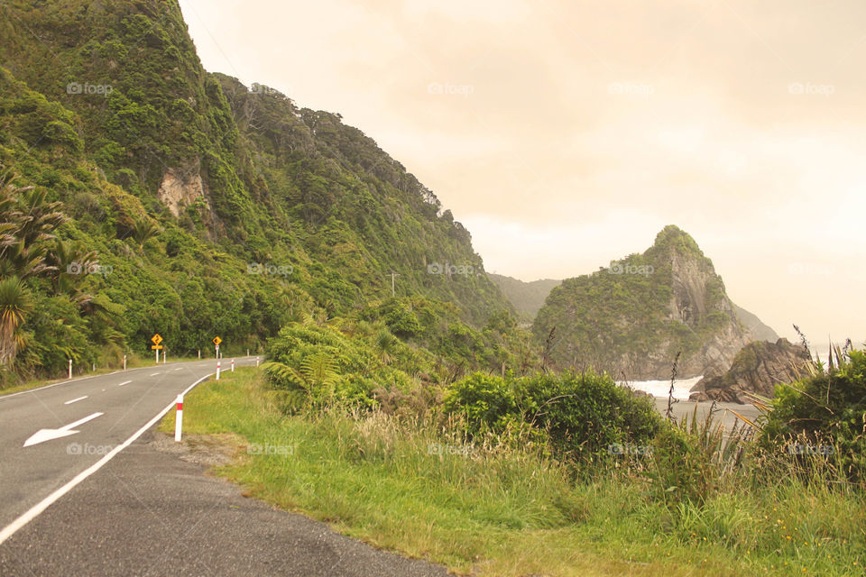 Empty road by mountains against sky