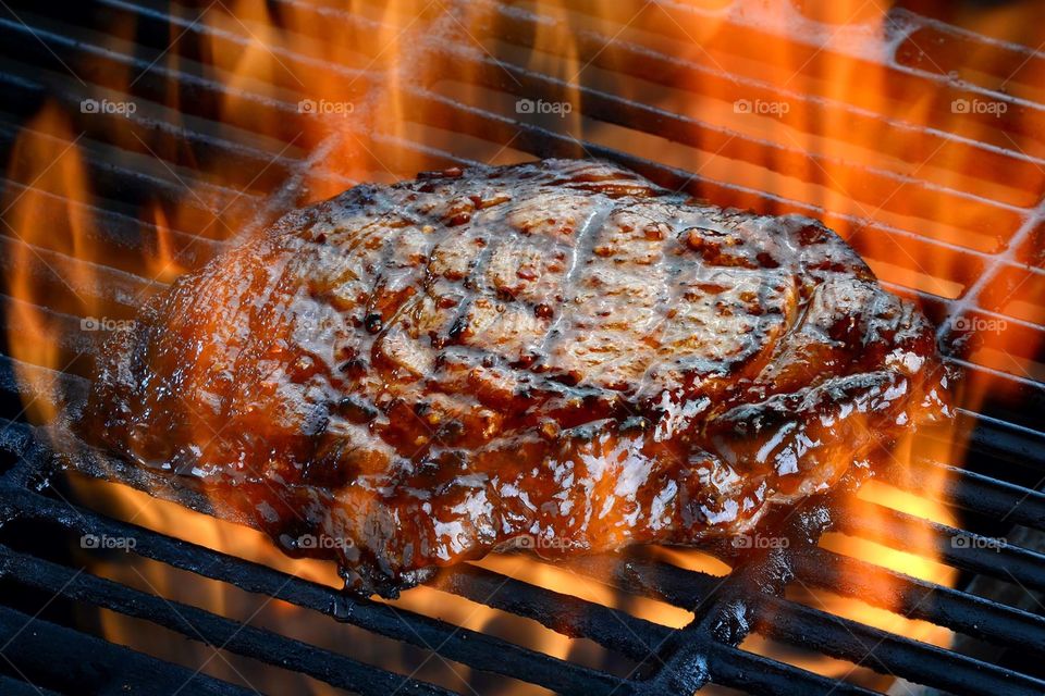 Rib eye steak on a hot flaming barbecue grill