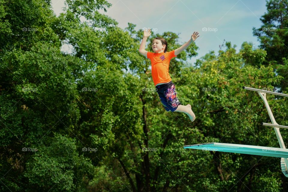 Boy Leaping Off A Diving Board