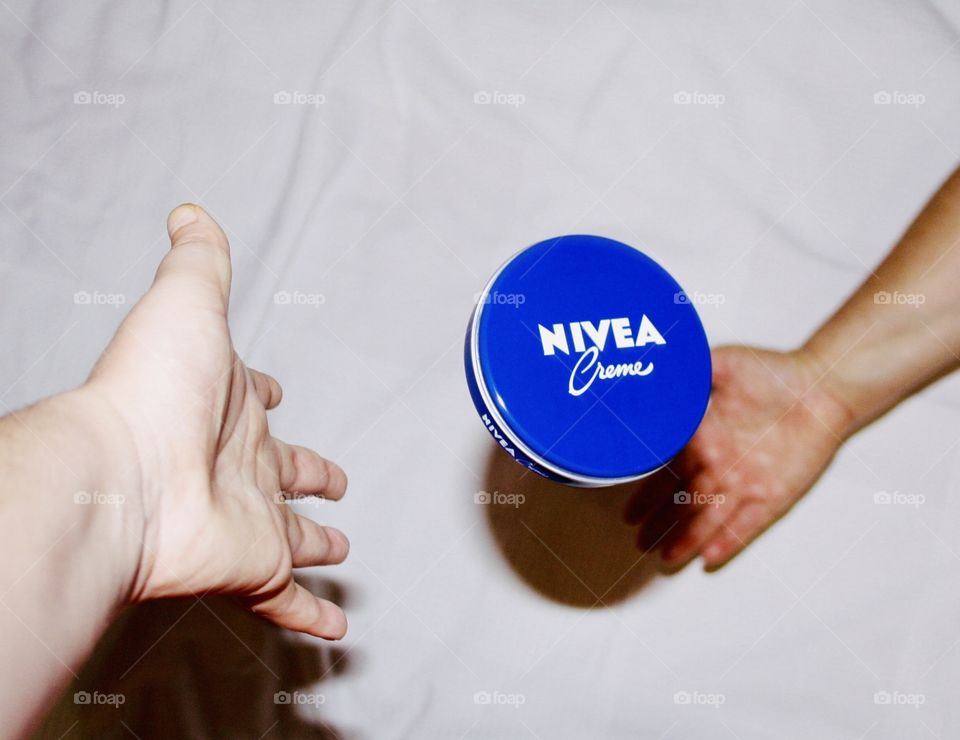 It is Nivea cream. Handcream. With my hand I drop the box of cream on the floor and the model's hand catches the box. I have captured the cream box with the camera in the air.