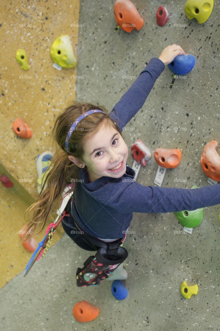 Girl climbing on rock wall