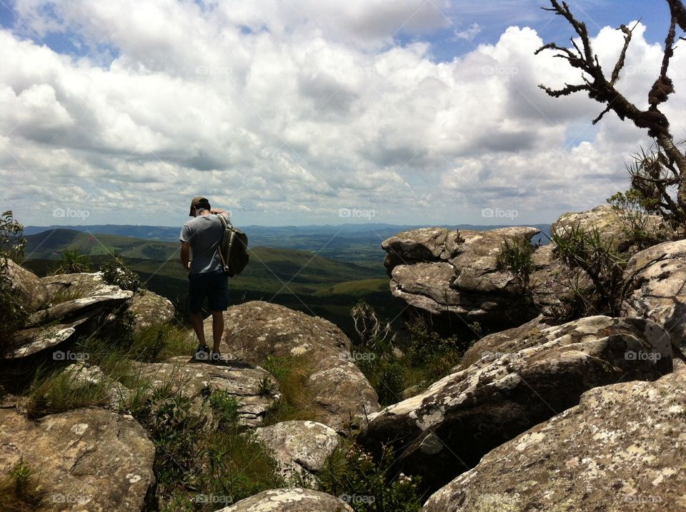 Man on the top of a rock staring the landscape 