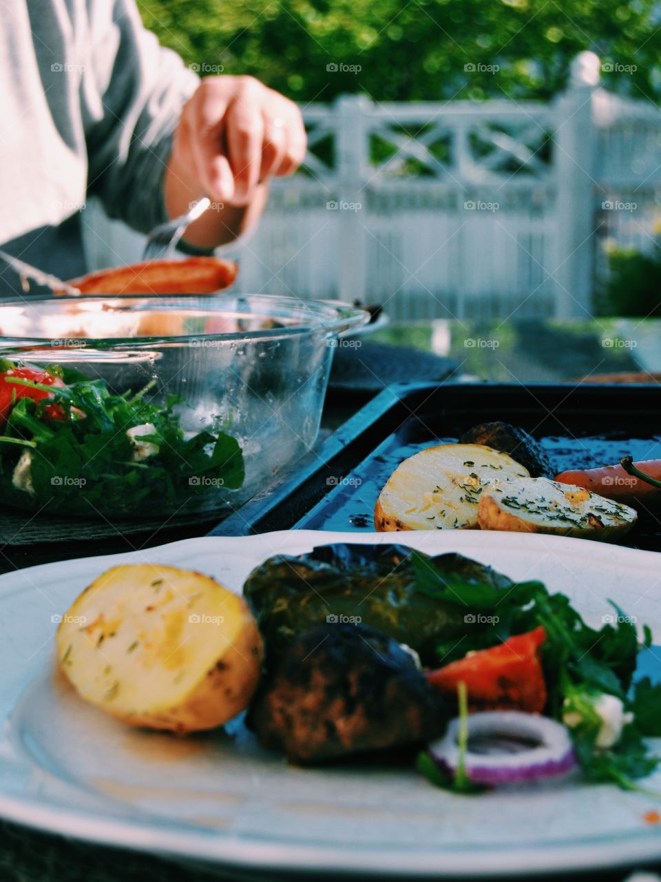 A person preparing vegetable on barbecue