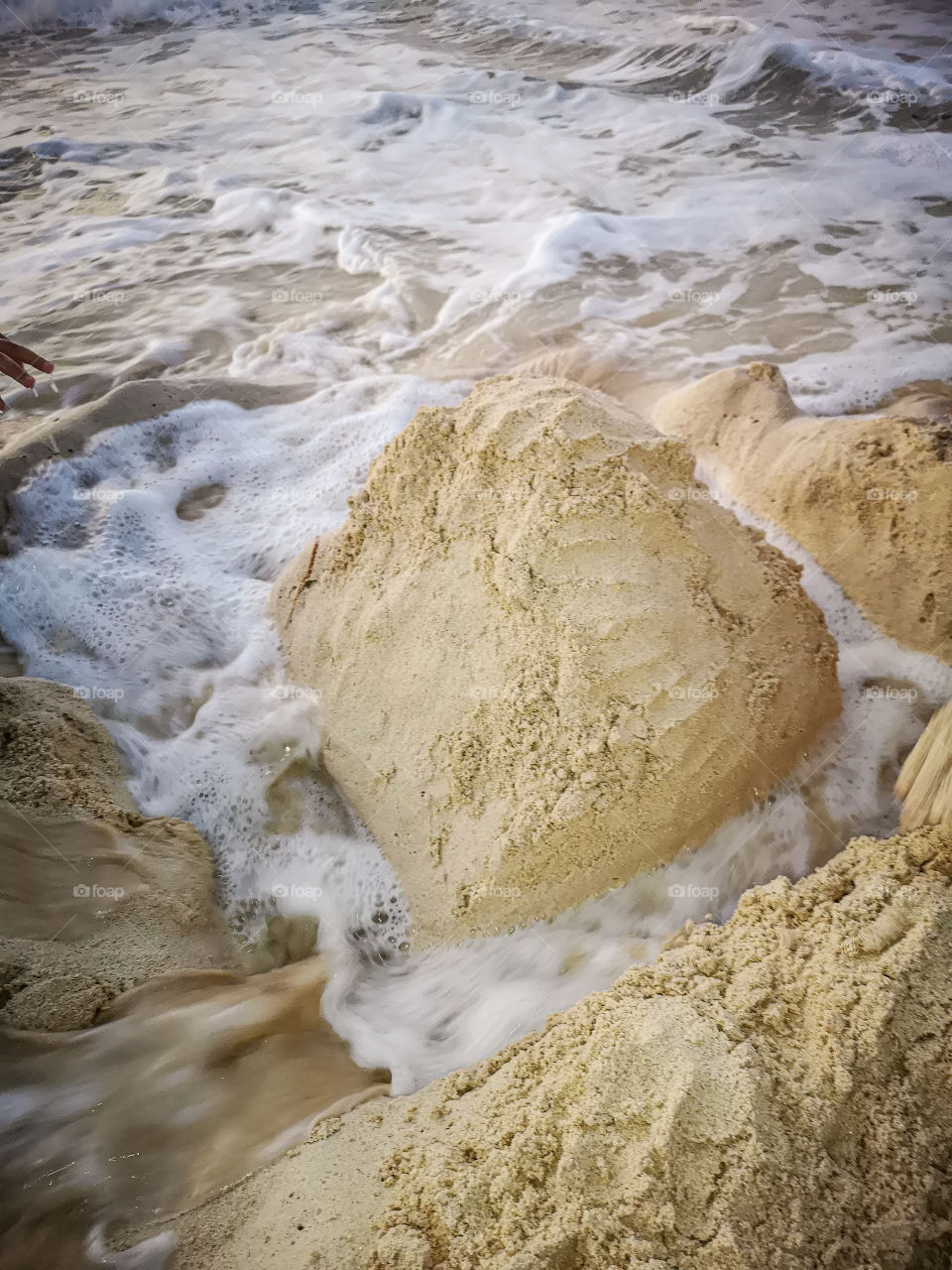 After we made a mountain peak by using beach sand, the sea waves came around it and made a beautiful sight!