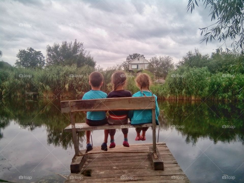 Сhildren on a bench by the river