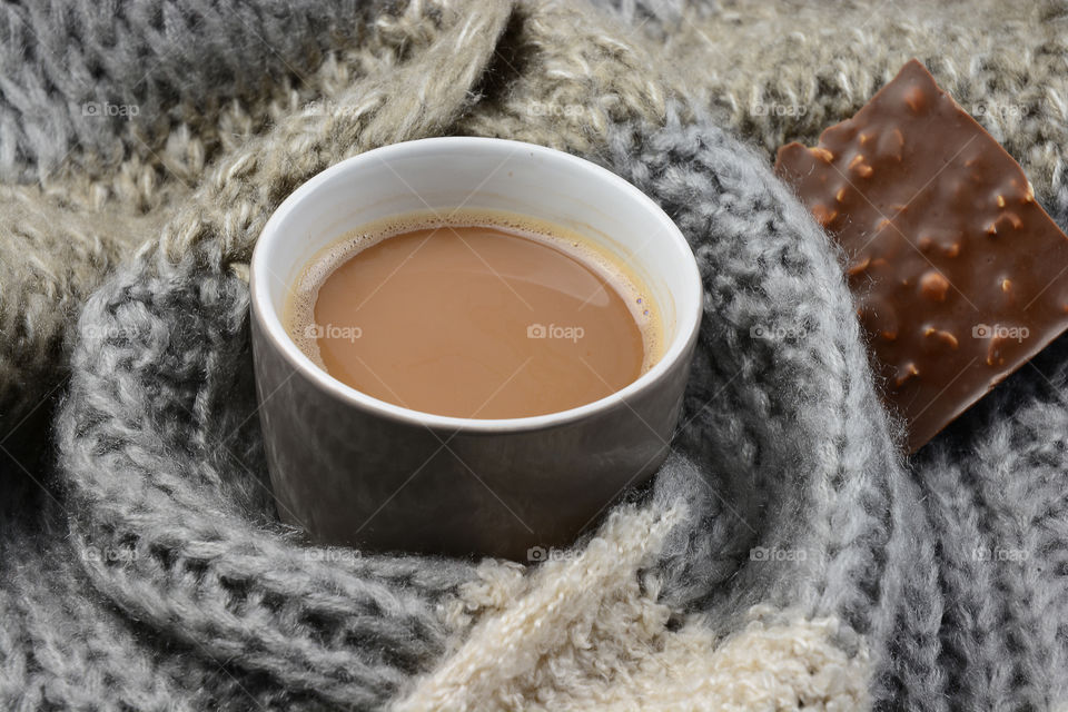 cup of hot chocolade  in a warm woolen blanket sjawl