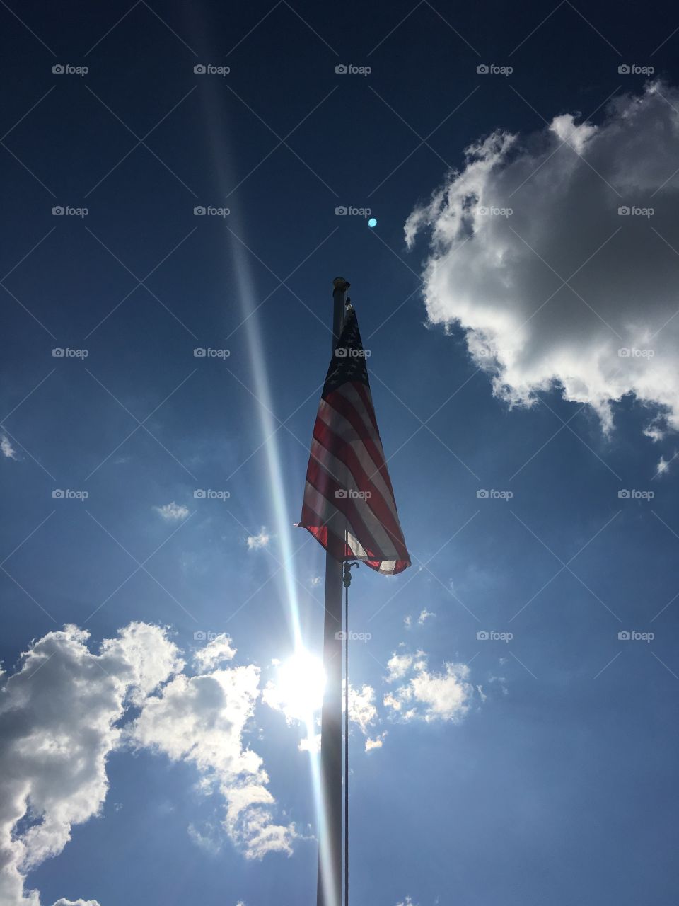 This is a picture of the American flag on a pole on a bright sunny day as you could see this guy in the background it is very bright and beautiful. I will be taking more pictures of the American flag. We love the USA  flag because we are from here I hope you enjoy all my photos and pictures.