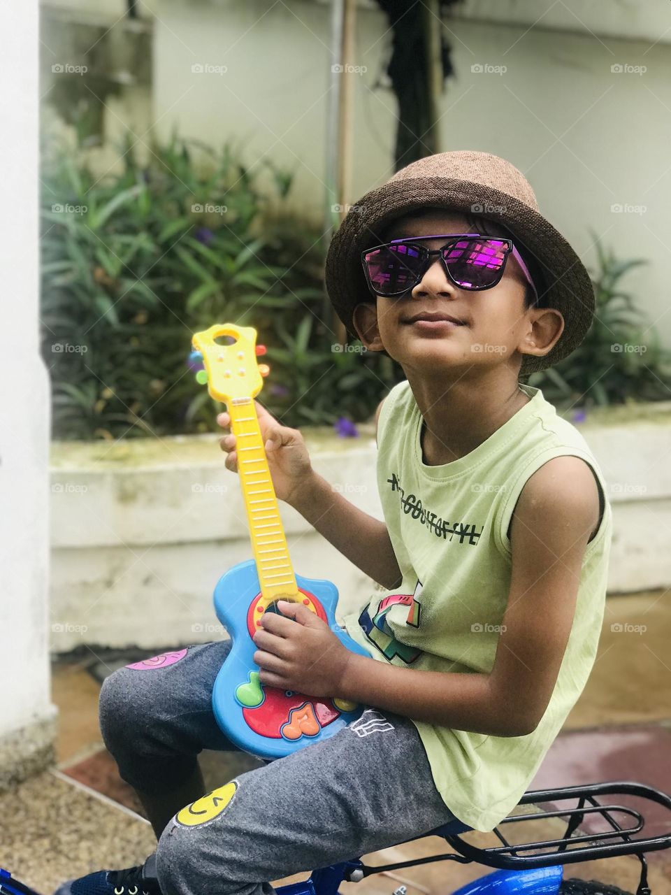 A crazy and funky style boy with guitar hat eyeglasses 