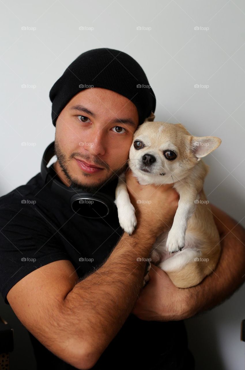 stylish guy in black clothes, with headphones and his best friend, a dog. a twenty-three-year-old teenager, a new generation.