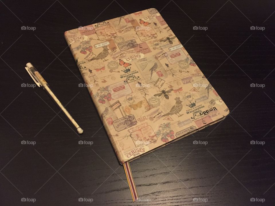 A pen and a notebook on a dark desk