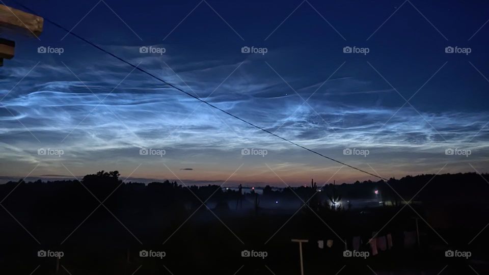 underexposed long exposure photo of my village at night. in the sky, summer ionized clouds are practically the northern lights, which are only in summer.