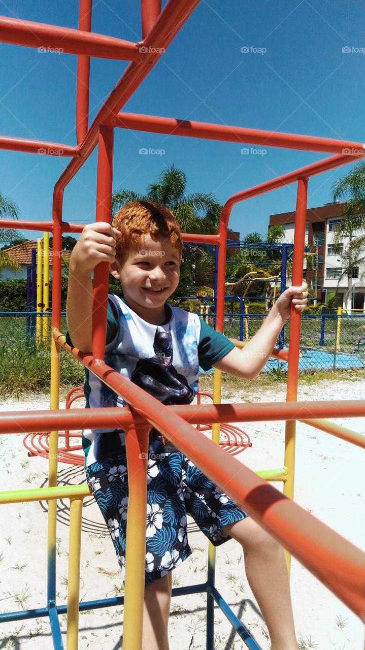 Boy playing on jungle gym at playground