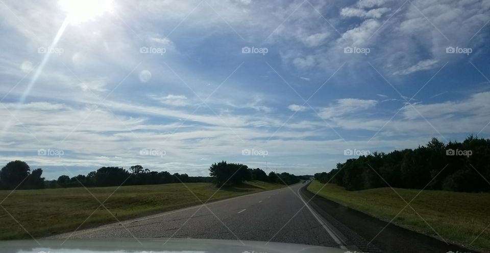 An open road beneath a blue sky.