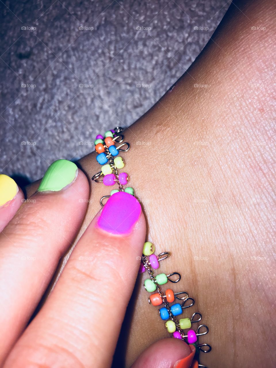 Colorful ankle bracket with neon nail polish 