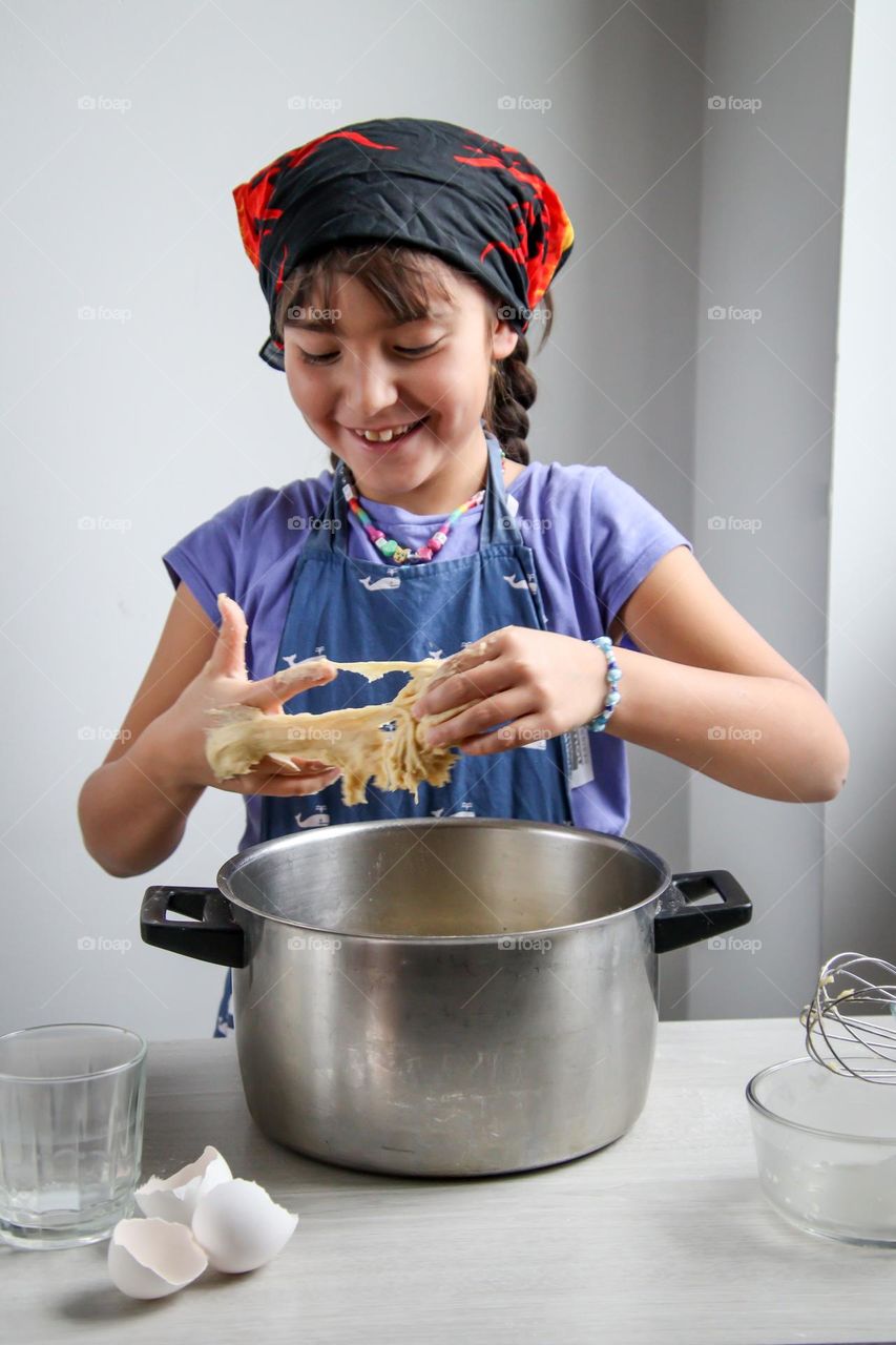 Excited girl is helping to make bread