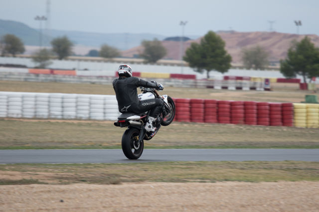 Speed motorbike doing a wheelie on track