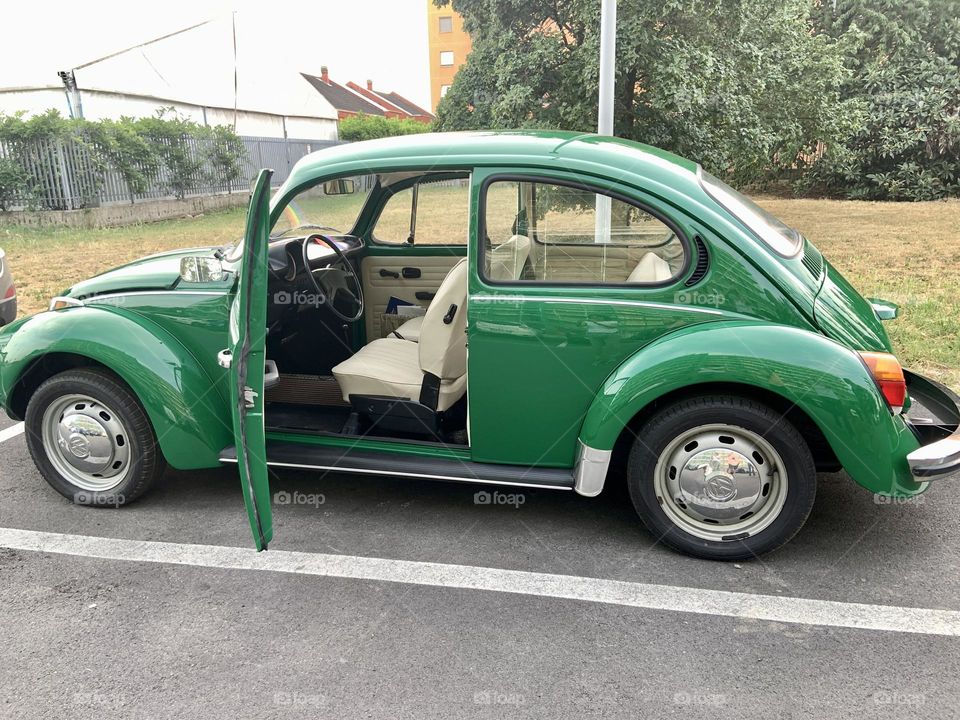 Green fusca Volkswagen with white chairs 