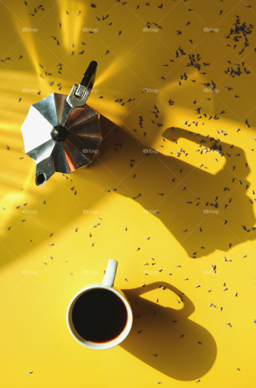 Working desk with french press coffee and cup of hot coffee on yellow background. Top view, copy space, mockup. Creative art.