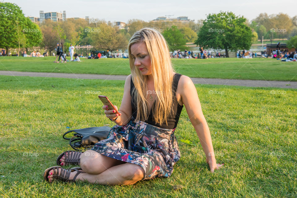 Woman tourist from Sweden 30 years plus taking a selfie in Hyde park in London.