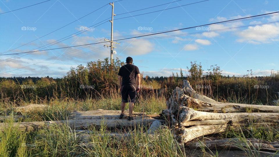 Man standing on driftwood