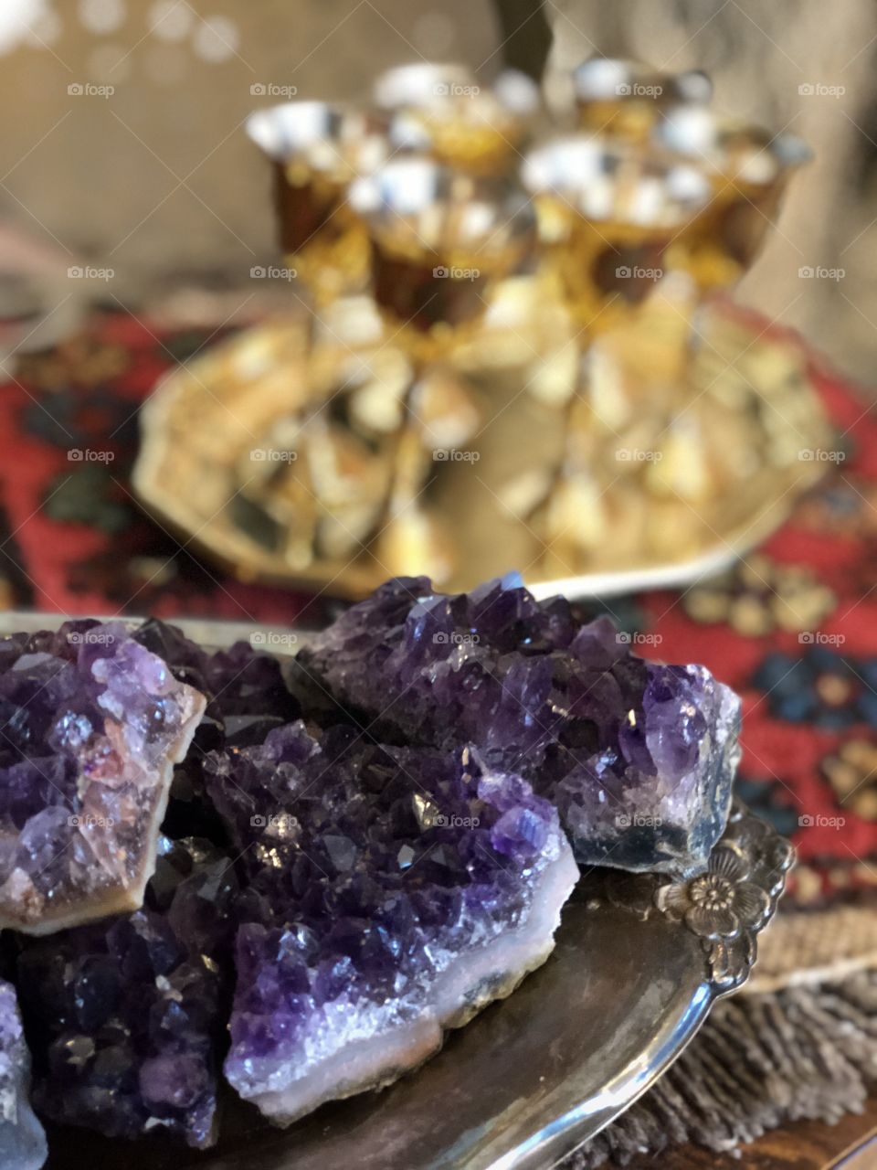 Amethyst stones placed in front of a gold wine set 