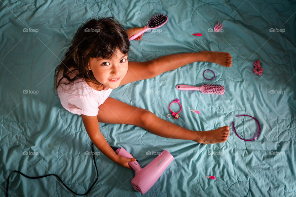 Cute girl is taking care of her hair