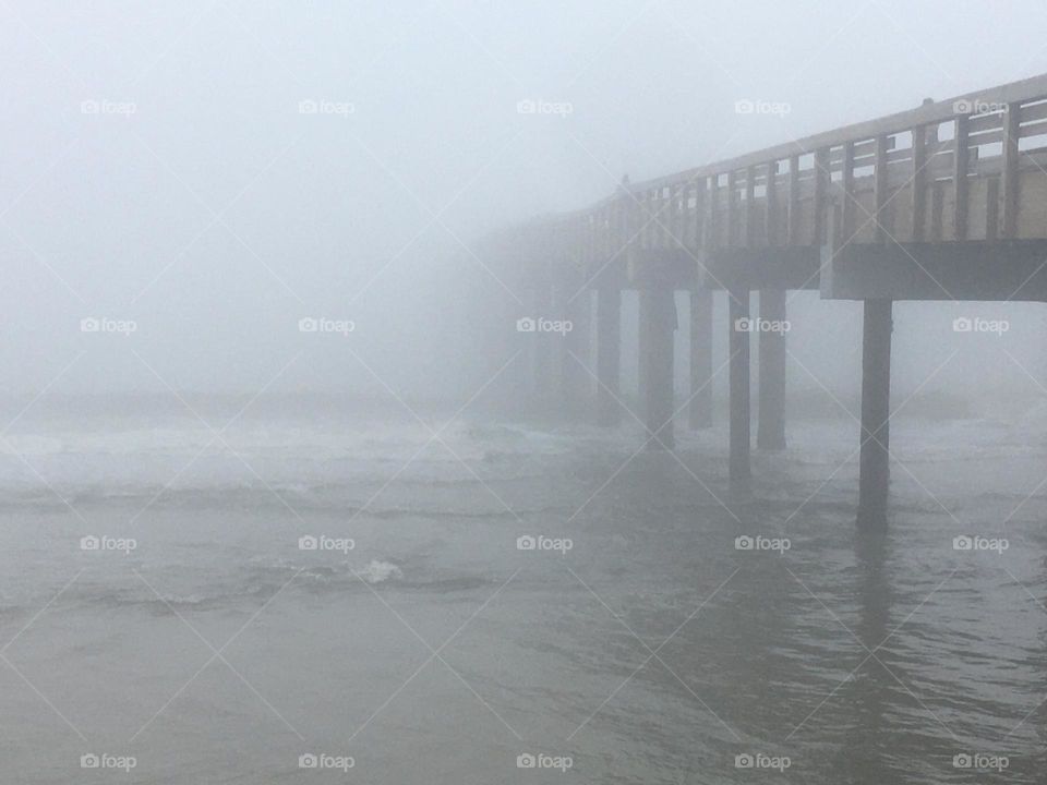 A dock disappears into thick, soupy fog