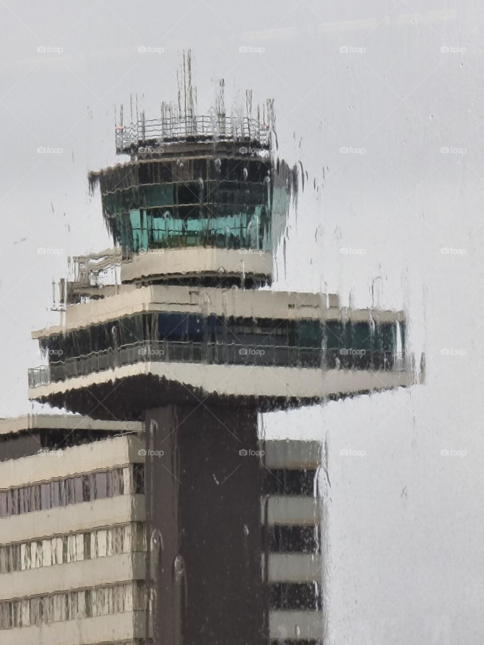 Airport tower seen through window on a rainy day