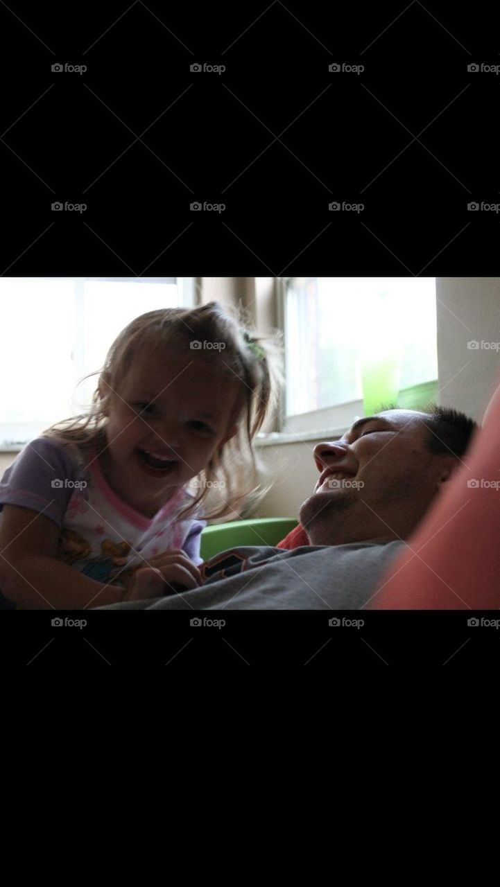 Little girl and dad laughing and playing