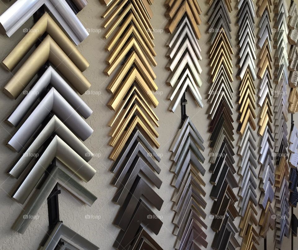 Metal golden and silver frames samples on a wall 