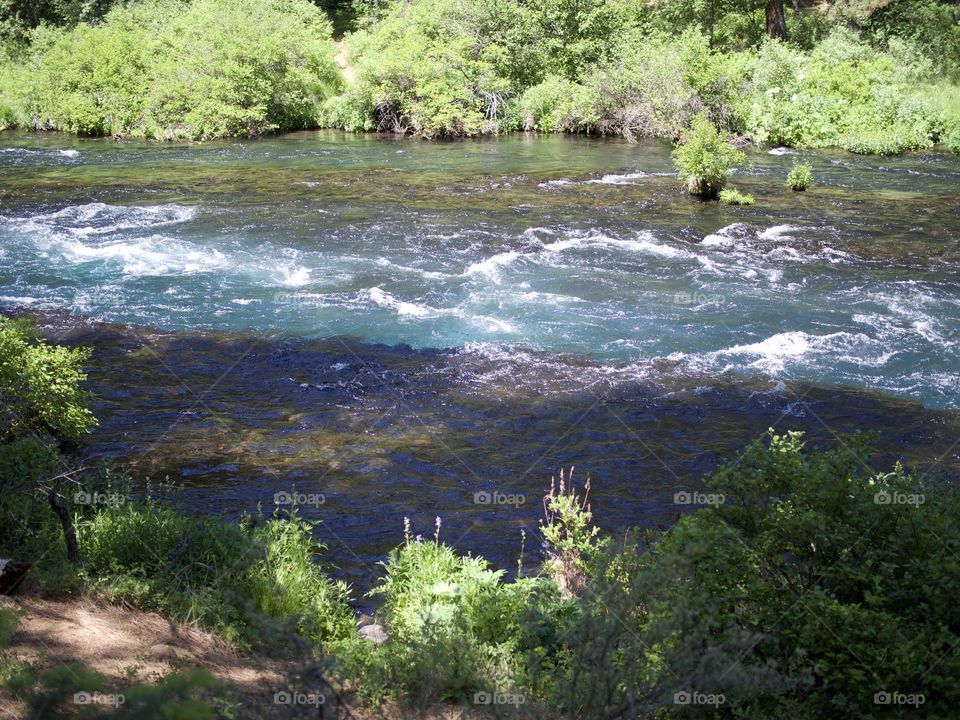 The absolutely stunning turquoise waters of Wizard Falls in the Metolius River on a sunny summer morning in Central Oregon. 